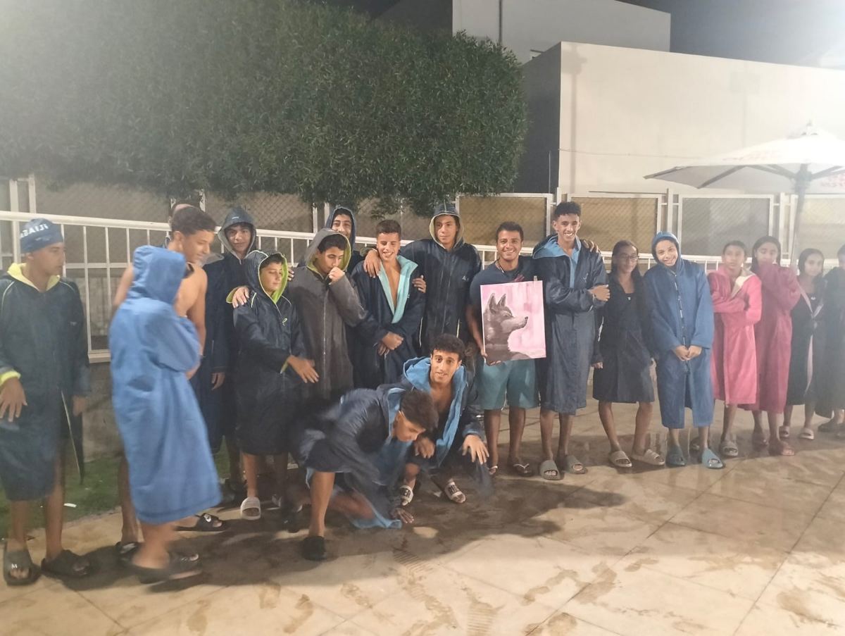 A swimming squad in robes after training